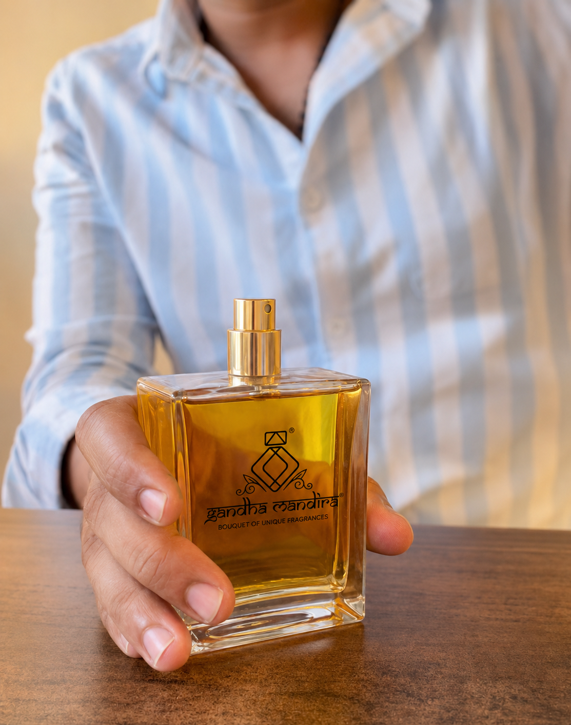 Finished golden Gandha Mandira perfume bottle presented in hand
