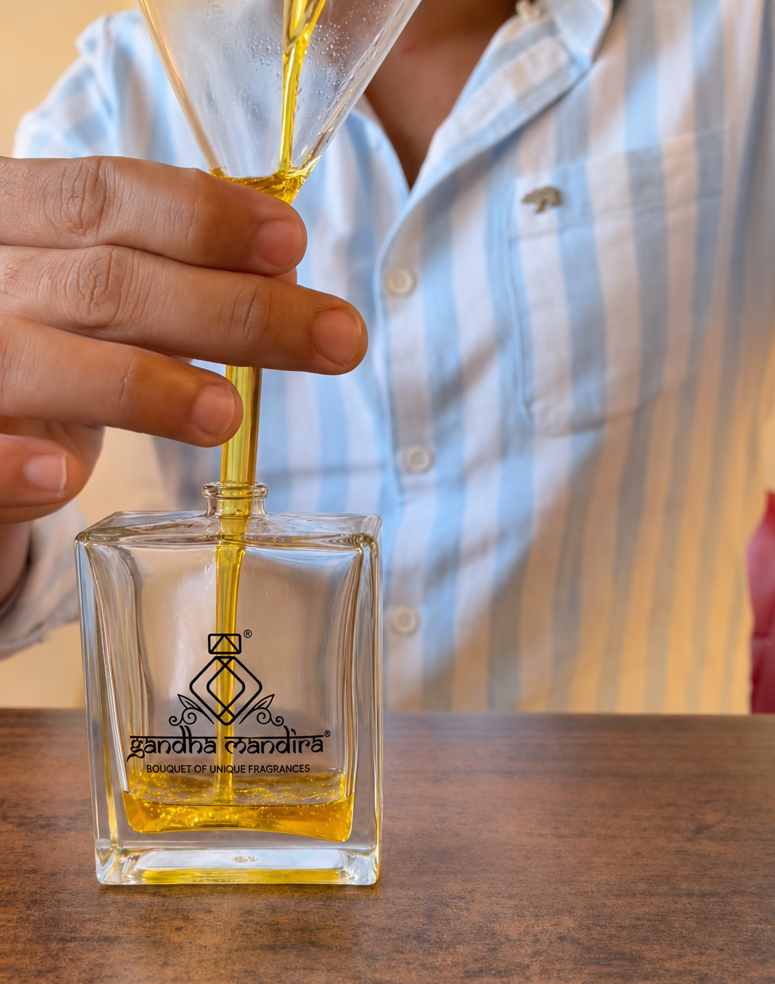 Fragrance being funneled into a crystal Gandha Mandira perfume bottle